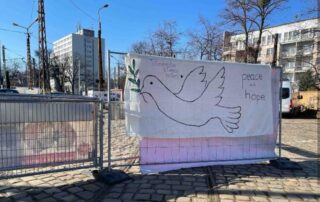 Tiftlingerröder*innen hissen Friedensflagge vor einem Geflüchtetencamp in Polen